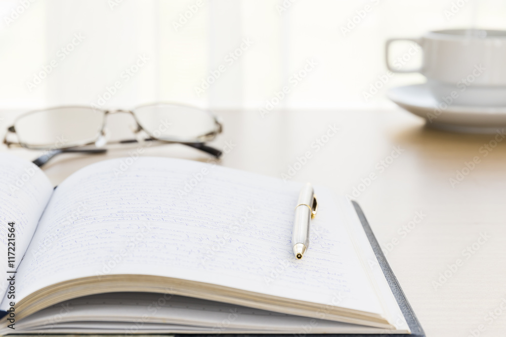 Pen put on a book with on the desk