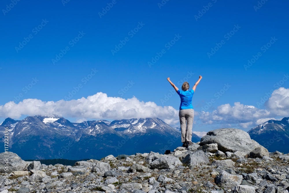 Woman in successful pose on mountain top.  Raibow mountain in Garibaldi Provincial park near Whistler, British Columbia, Canada. 