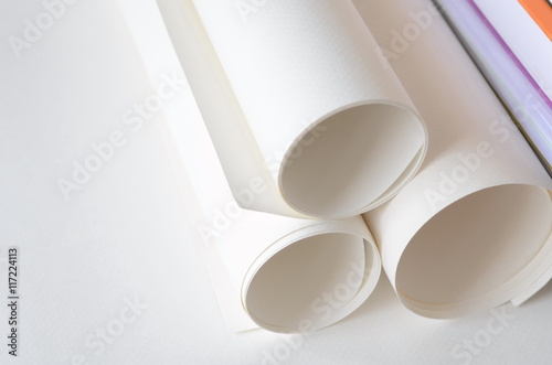Roll of white papers with copy space for text on left side.