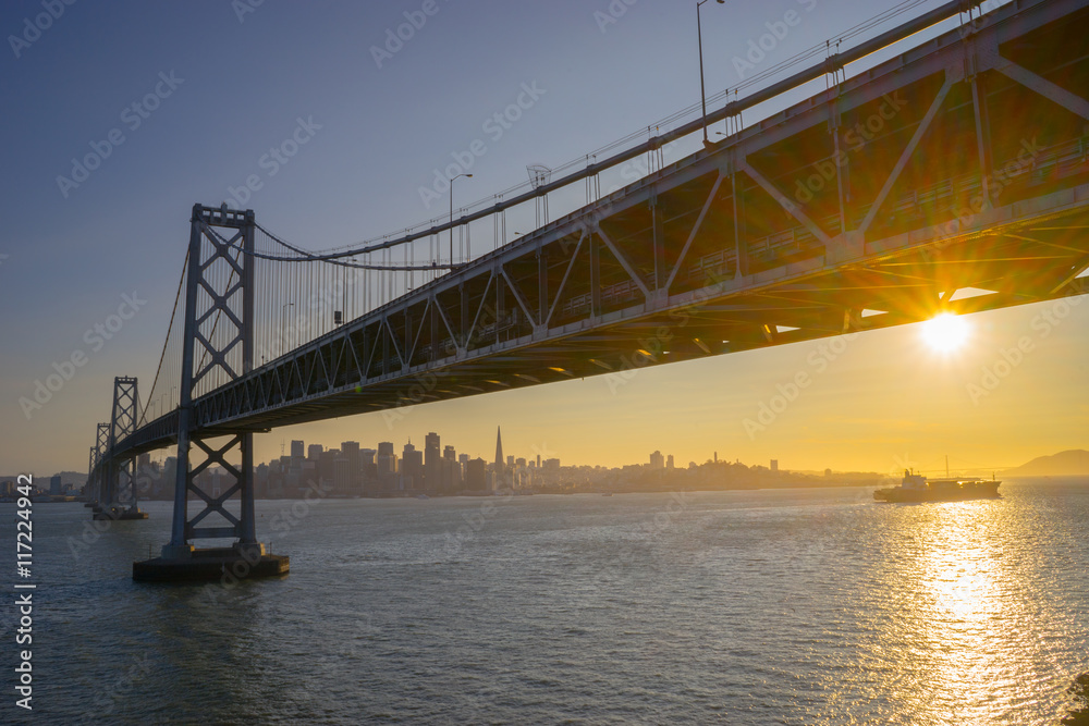 Container ship sails along San Francisco Bay at sunset Container ship sails along San Francisco Bay at sunset