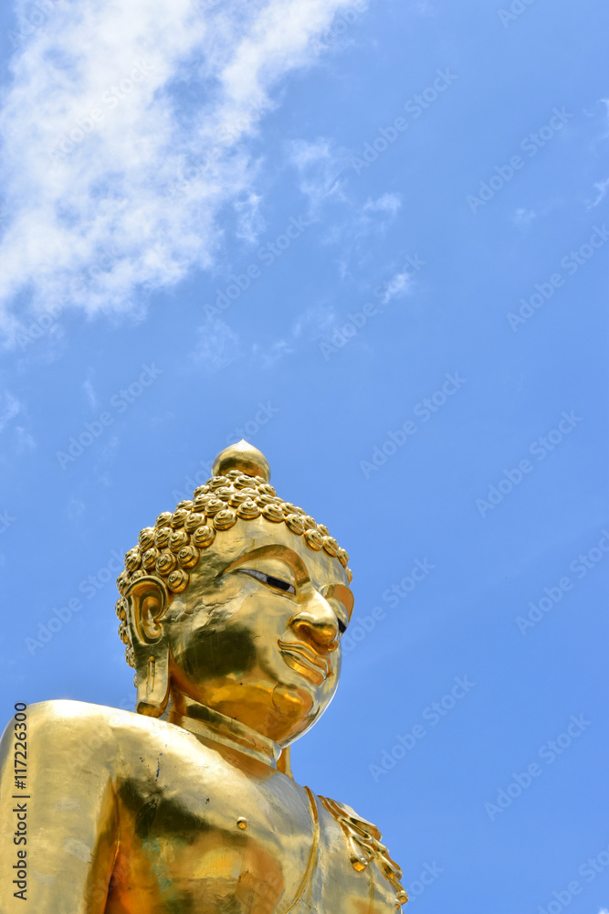 big gold buddha with cloud blue sky.