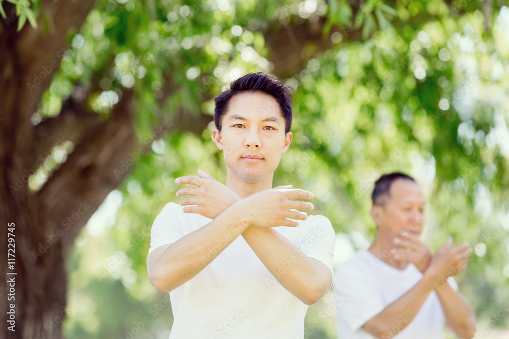 People practicing thai chi in park People practicing thai chi in park