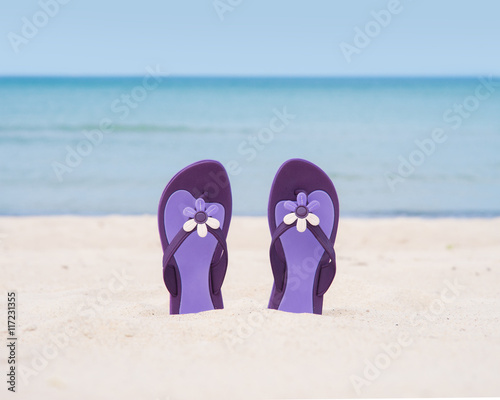 Beautiful purple flip-flops on the beach