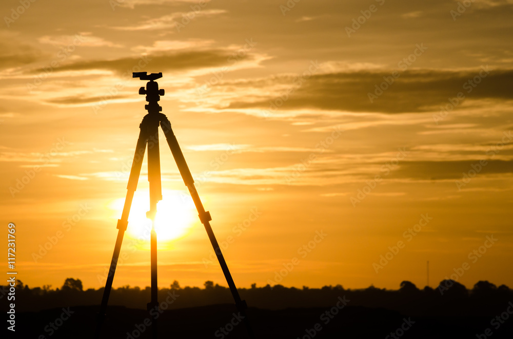 silhouette tripod with sunset sky background.