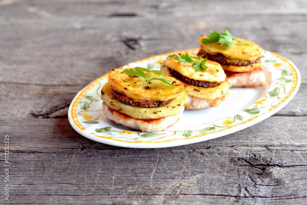 Fried Turkey breast steaks with spice potatoes, zucchini and parsley on a plate isolated on old wooden table. Delicious lunch or dinner recipe Fried Turkey breast steaks with spice potatoes, zucchini and parsley on a plate isolated on old wooden table. Delicious lunch or dinner recipe