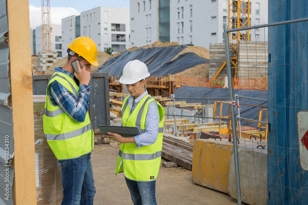 engineers using mobile phone at construction site engineers using mobile phone at construction site