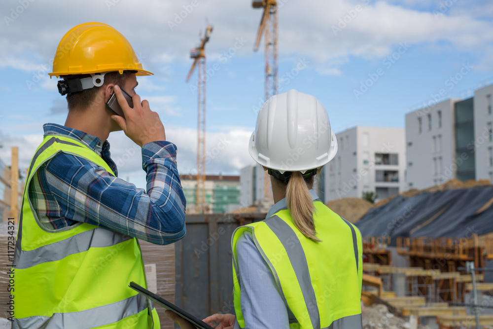 engineers using mobile phone at construction site engineers using mobile phone at construction site