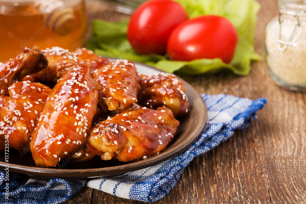 Baked chicken wings in honey sauce sprinkled with sesame seeds. Baked chicken wings in honey sauce sprinkled with sesame seeds.