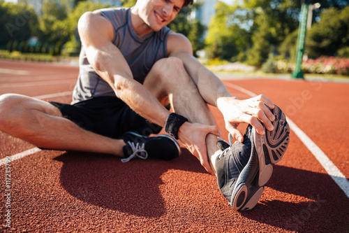 Cropped image of a runner suffering from leg cramp photo
