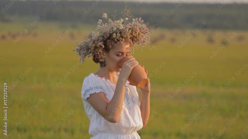 young beautiful girl is drinking milk from a jug on the nature. young beautiful girl is drinking milk from a jug on the nature.