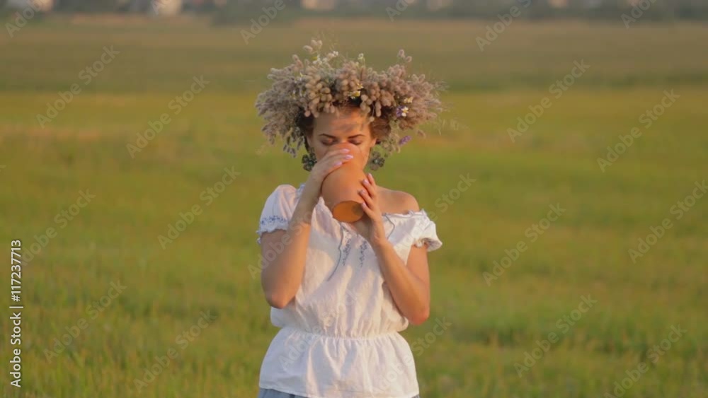 young beautiful girl is drinking milk from a jug on the nature. young beautiful girl is drinking milk from a jug on the nature.