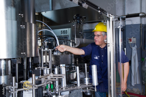 skilled worker while fixing a bottling plant during maintenance work