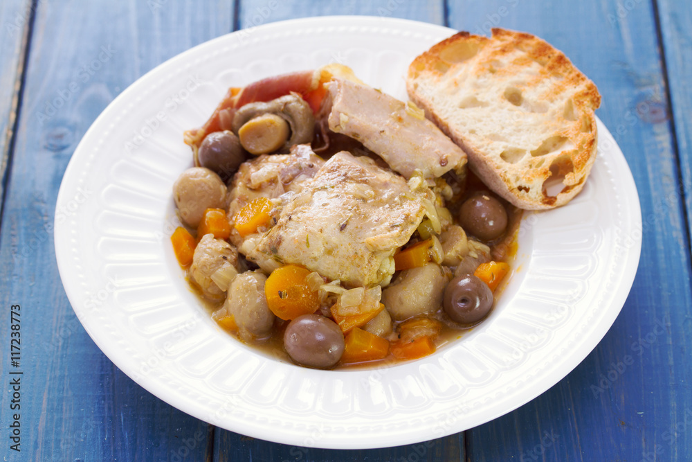 rabbit stew with mushrooms and carrot on white dish on blue wooden background rabbit stew with mushrooms and carrot on white dish on blue wooden background