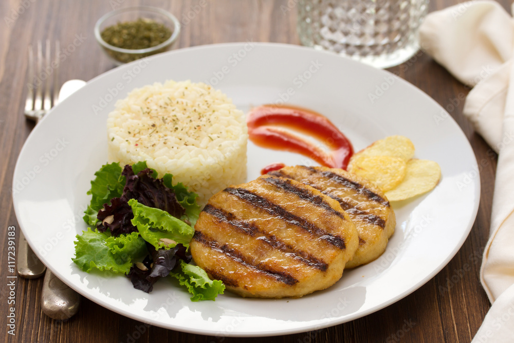 grilled hamburger with rice, salad and chips on plate grilled hamburger with rice, salad and chips on plate