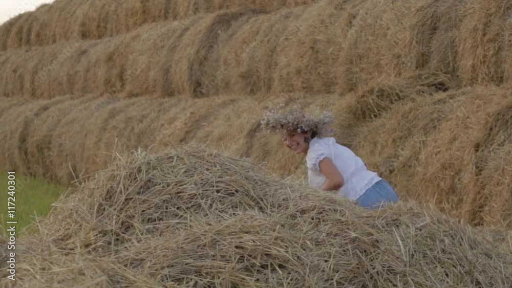 young girl in a wreath resting in straw haystack. young girl in a wreath resting in straw haystack.