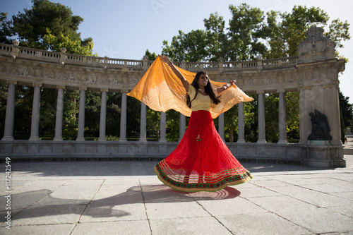Young beautiful traditional indian woman dancing outdoors
