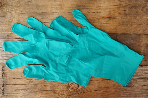 Green rubber gloves on the old wooden floor.