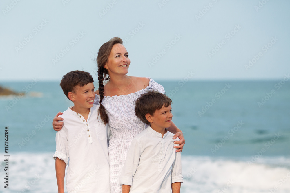 Portrait of a cheerful, happy mother and sons on beach Portrait of a cheerful, happy mother and sons on beach