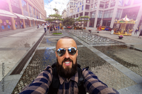 young happy smiling man traveler make selfie on the city01 photo