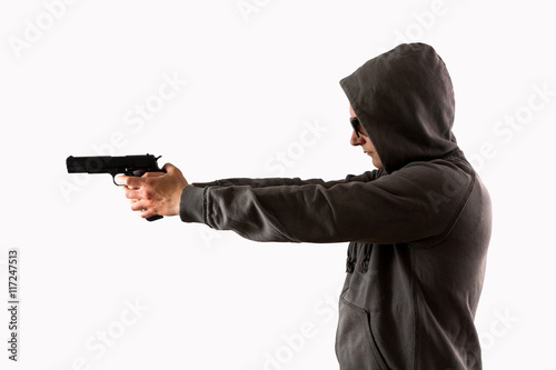 Mann im Kapuzenpullover zielt mit Pistole vor weißem Hintergrund freigestellt