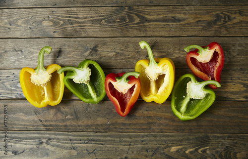 Stampa su Tela Colorful sweet bell pepper halves on a wooden table top background