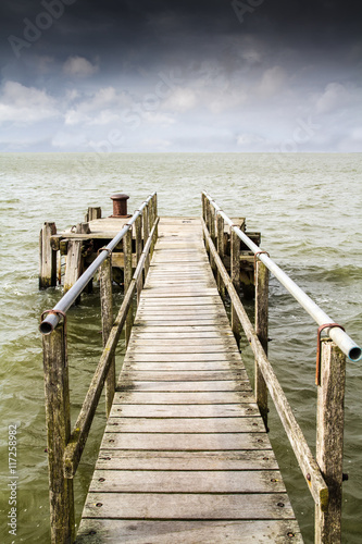 Old boat pier stretching out to sea