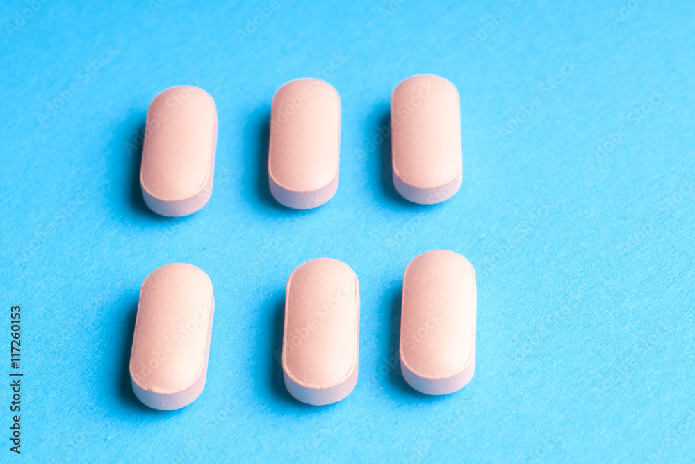 Many pills and tablets isolated on light blue background Many pills and tablets isolated on light blue background