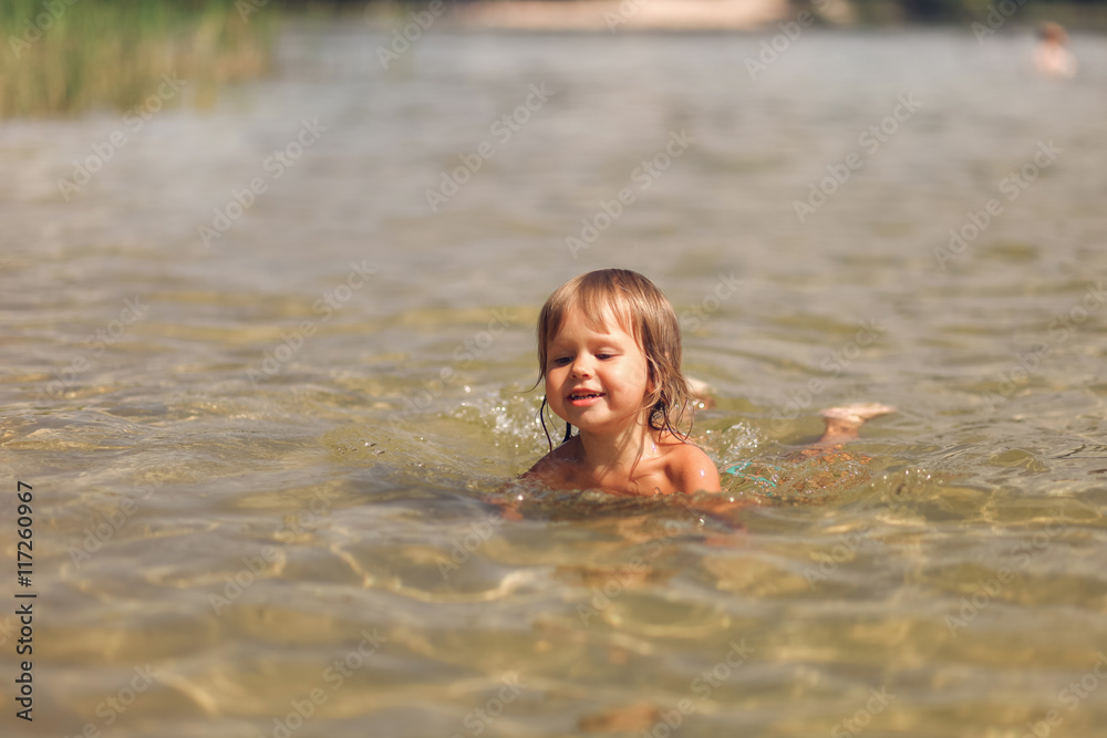 Child swim in lake.