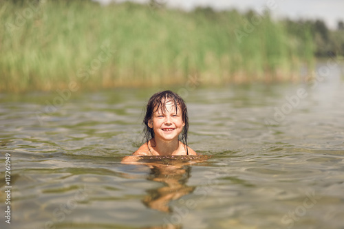 Child swim in lake.