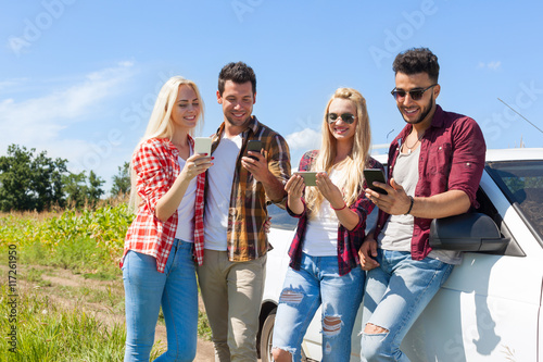 Friends using smart phone chatting outdoor countryside people messaging