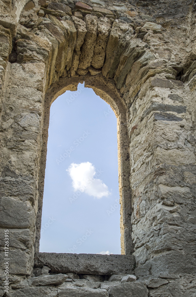White small cloud in old stone arc window