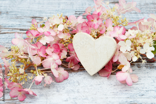 flower and wooden heart lying on wood