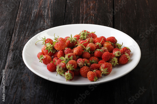 strawberry in plate on wooden background