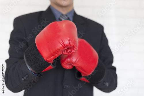 businessman in suit with red boxing gloves