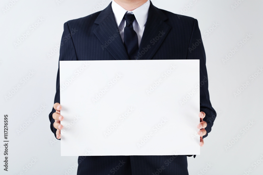 Businessman holding blank sheet of paper in his hands Businessman holding blank sheet of paper in his hands