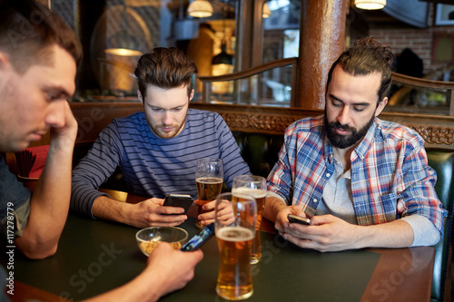 men with smartphones drinking beer at bar or pub