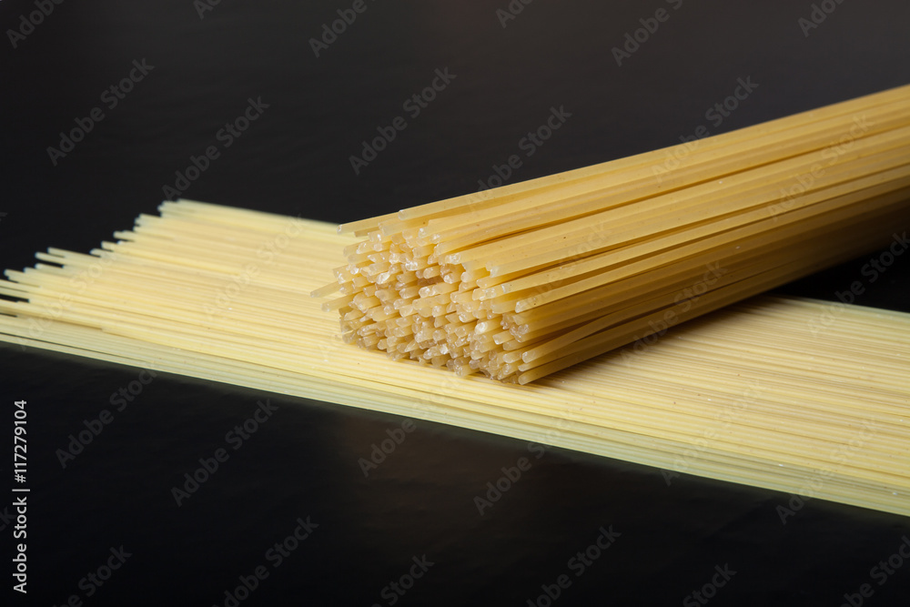 Pasta spaghetti on a black background. Selective focus. Space fo Pasta spaghetti on a black background. Selective focus. Space fo