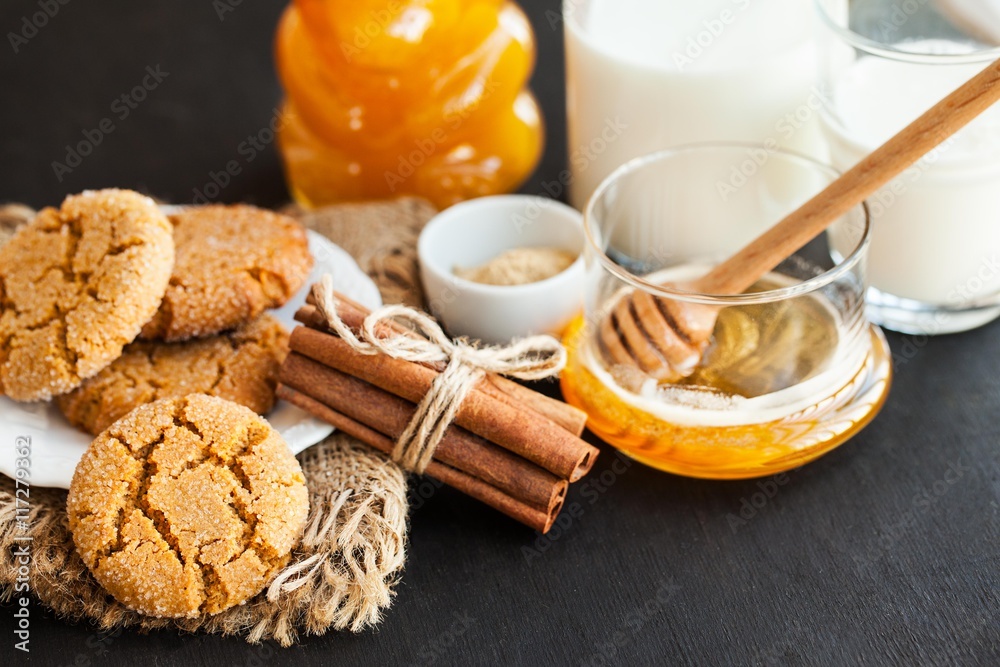 Honey ginger cookies with milk on a black background, selective focus Honey ginger cookies with milk on a black background, selective focus