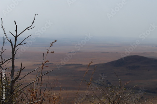 View from a hill of a nature reserve into the wide landscape of South Africa