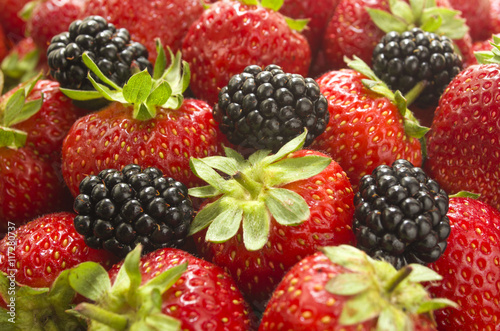 Ripe strawberry and blackberry close up. Background of summer berries.