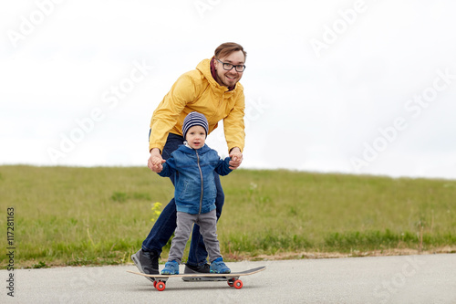 happy father and little son on skateboard