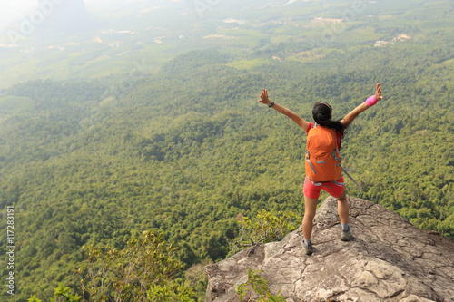 young asian woman hiker enjoy the view on mountain peak cliff