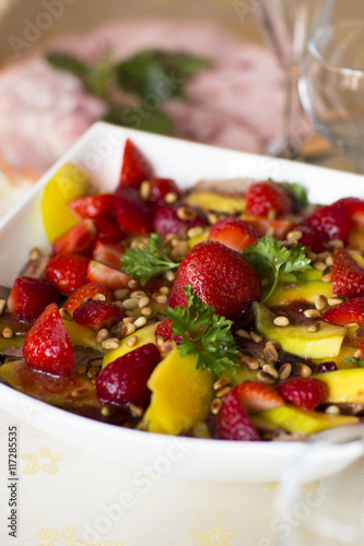Fruit salad  dessert. Strawberries and mangoes in sweet and sour sesame sauce. 