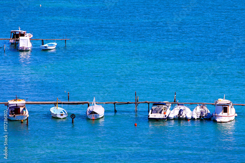 Boats docked at pier with blue sea photo