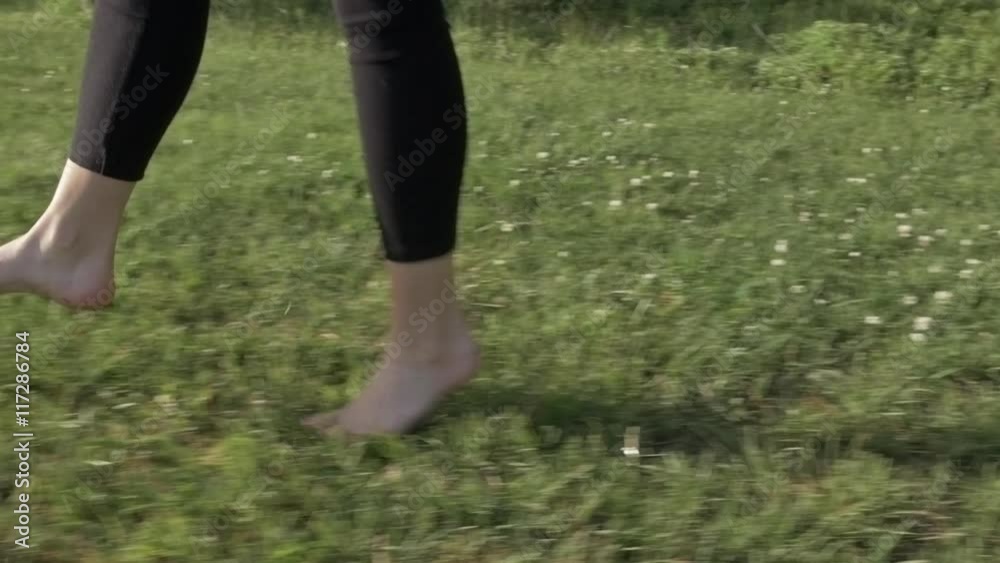 A happy young woman is jumping, playing and dancing around barefoot on grass in the summertime. Happiness, good life, relaxed lifestyle concept. Steadicam shot slow motion. Natural look. A happy young woman is jumping, playing and dancing around barefoot on grass in the summertime. Happiness, good life, relaxed lifestyle concept. Steadicam shot slow motion. Natural look.