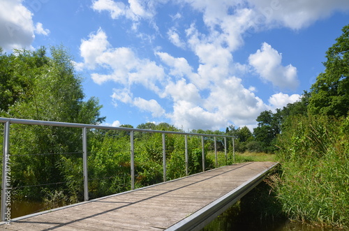 Bootssteg am Fluss in grüner Sommerlandschaft