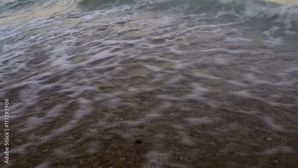 Waves rolled on beautiful sandy beach with seashells Waves rolled on beautiful sandy beach with seashells