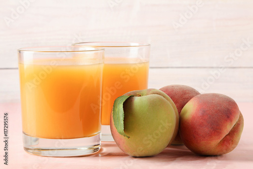 Fresh juice with peaches on wooden background.