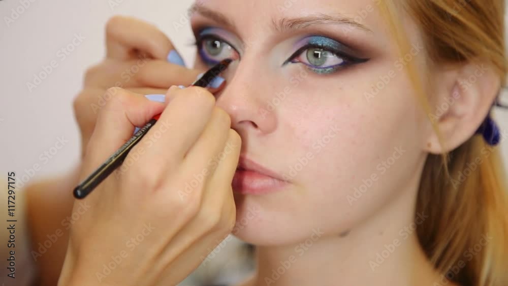 Make-up artist applying make up with a brush on model's face Make-up artist applying make up with a brush on model's face