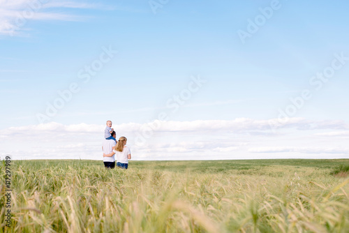 parents with the child walk across the field